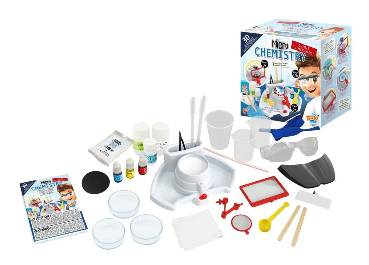 Buki Micro Chemistry science kit showing the illuminated magnification station, safety goggles, petri dishes, reagent bottles and 30-experiment instruction guide.