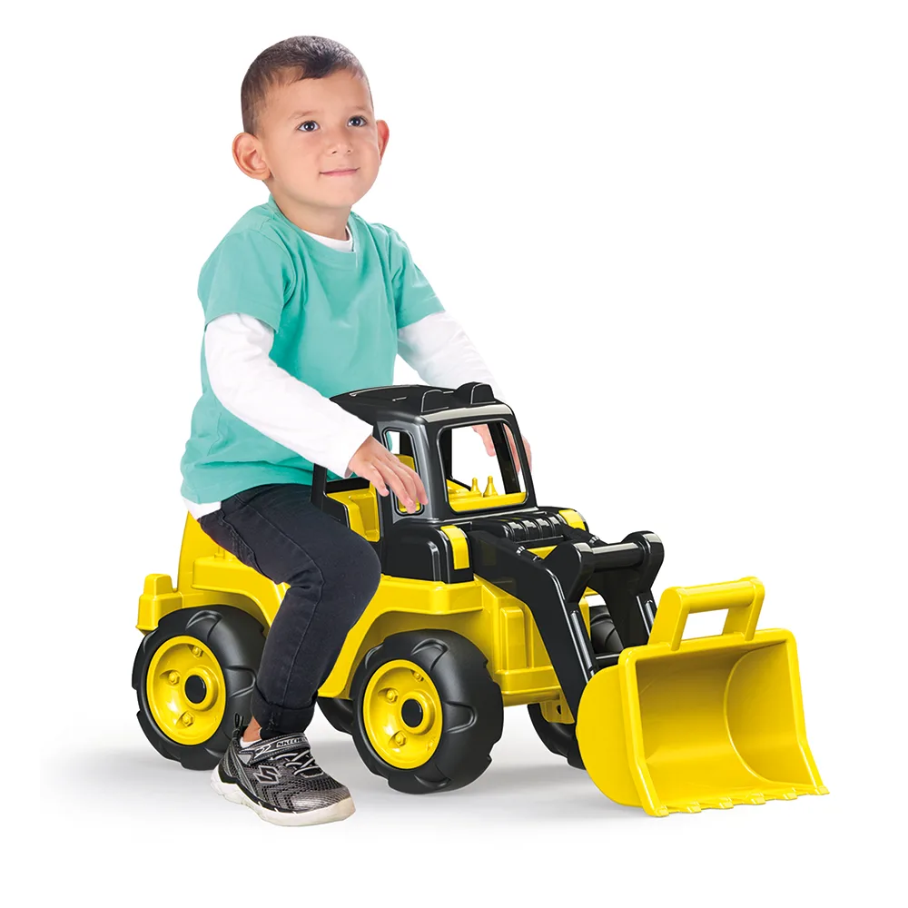 Young child aged around 3 sitting astride the Dolu Giant Foot to Floor Loader yellow ride-on, pushing with feet