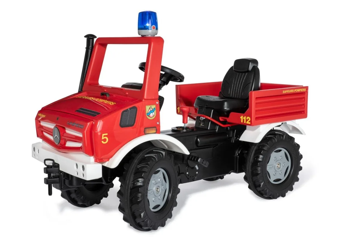Rolly Toys Fire & Rescue Mercedes Unimog pedal ride-on in red fire livery with blue flashing beacon, adjustable seat, and rear load bay, shown on white background.