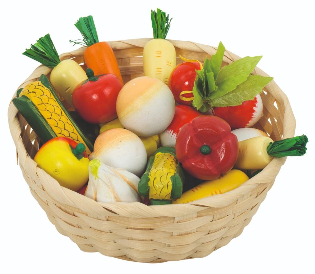 The Goki Vegetables in a Basket, a wicker shopping basket filled with a variety of colourful wooden play vegetables like carrots and tomatoes.