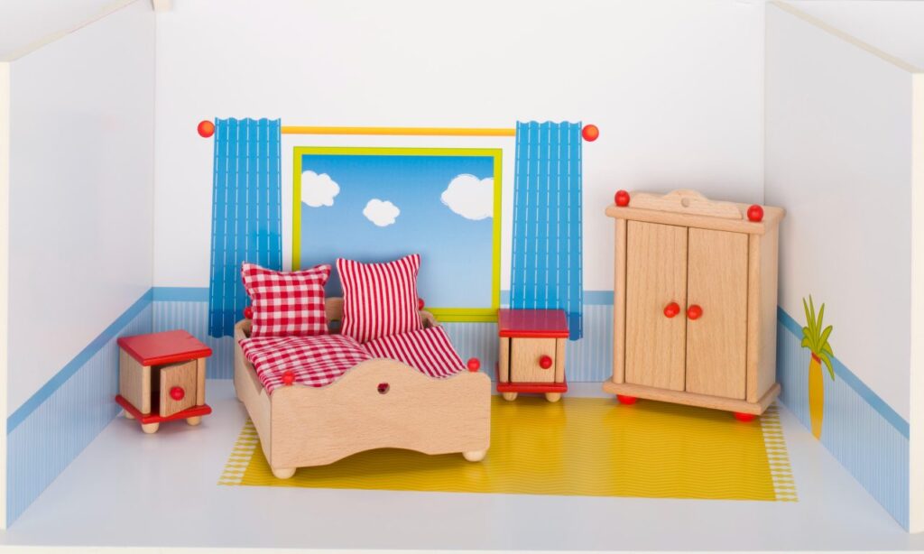 A Goki doll's house bedroom furniture set, including a bed with red gingham bedding, a wardrobe, and two bedside tables.