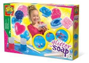 The SES Creative Making Glitter Soap kit, showing a girl with the finished sparkly soaps, and the included soap base, moulds, dyes, and glitter.