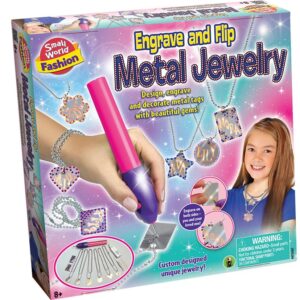 The box for the Small World Fashion Engrave and Flip Metal Jewelry kit, showing the battery-operated engraving tool and examples of engraved pendants.