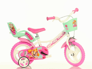 The Dino Bikes Paw Patrol 12-Inch Bike, a pink and mint green kids bicycle featuring Skye graphics, stabilisers, a front basket, and a doll carrier.