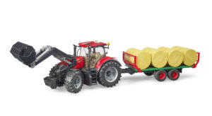 Red Case IH Optum 300 CVX tractor toy with a front loader, towing a bale trailer loaded with eight yellow round bales.
